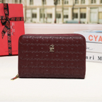 Brown wallet with embossed text and a red gift box in the background