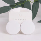 White jewelry box with 'Jewelry' text on a light background with green leaves.