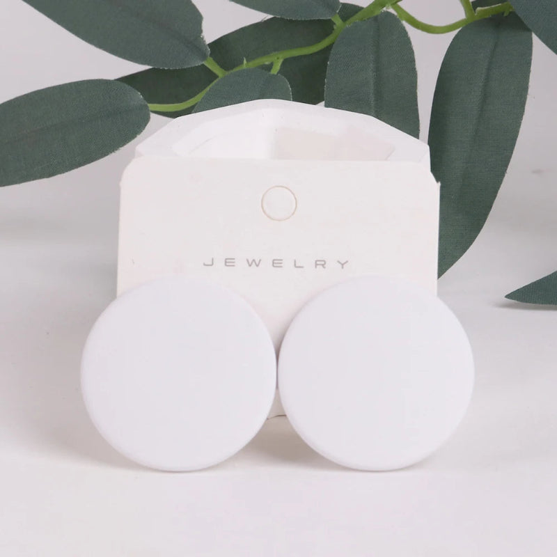 White jewelry box with 'Jewelry' text on a light background with green leaves.
