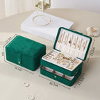 Green jewelry box with jewelry items on a light surface, showing dimensions.