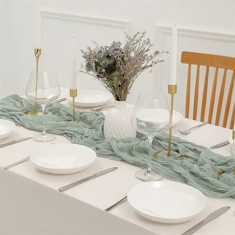 Elegant table setting with white plates, silverware, and a green runner.