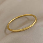 Gold bangle on a beige fabric background