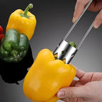 Peppers being held with a metal tool against a dark background