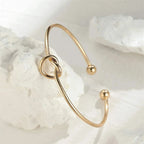 Gold bracelet on a white shell background