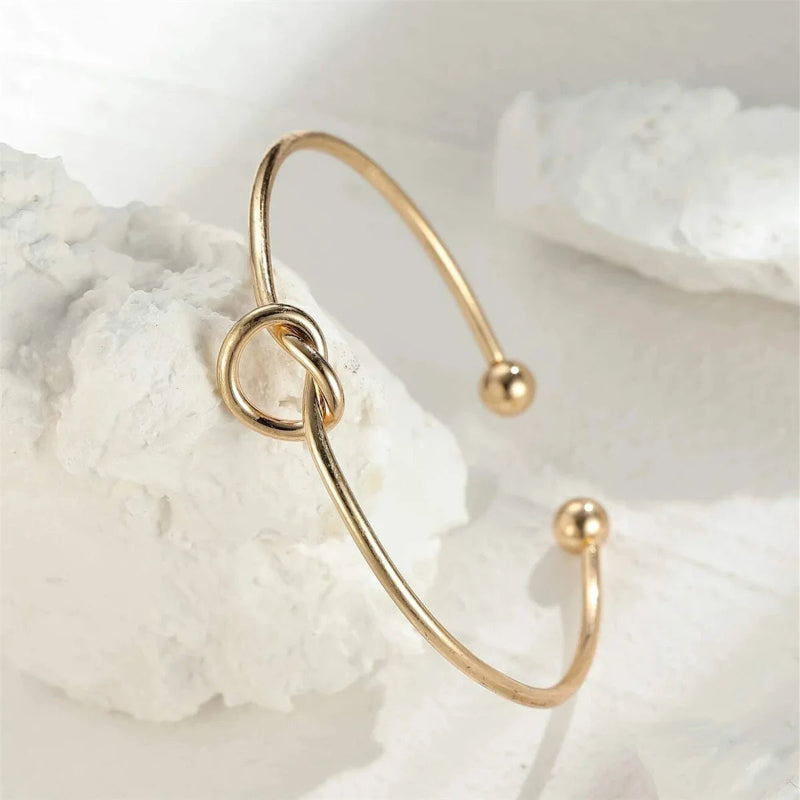 Gold bracelet on a white shell background