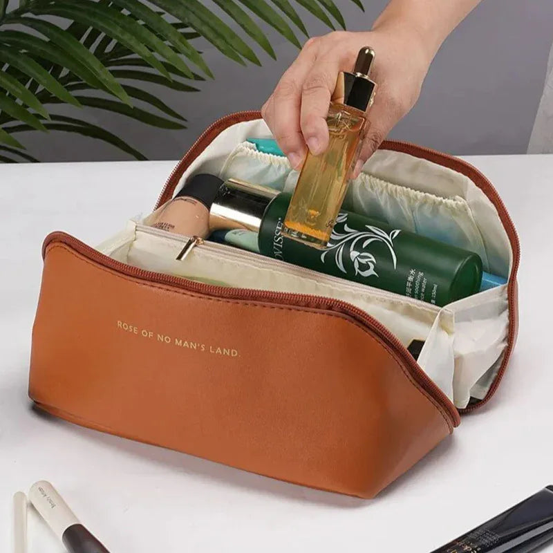 Brown toiletry bag with products on a white surface