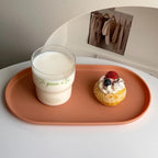 Cup of coffee and dessert on a pink tray with a mirror in the background