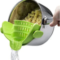 Green pasta scoop being used to serve pasta from a pot