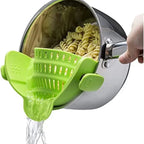 Green pasta scoop being used to serve pasta from a pot