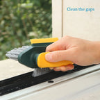 Hand using a brush tool to clean gaps near a window