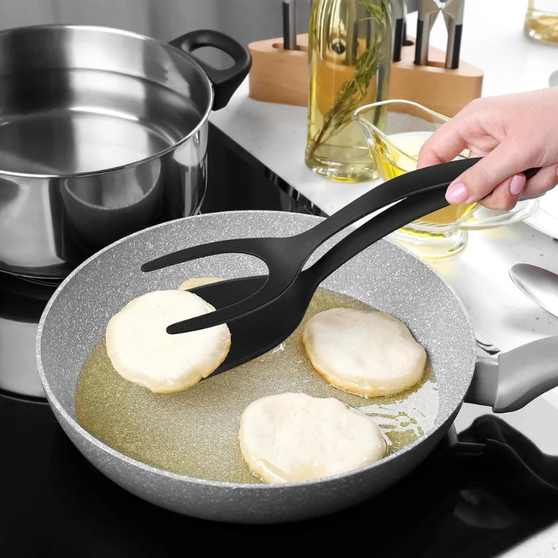 Person frying pancakes in a pan with a spatula on a stove.
