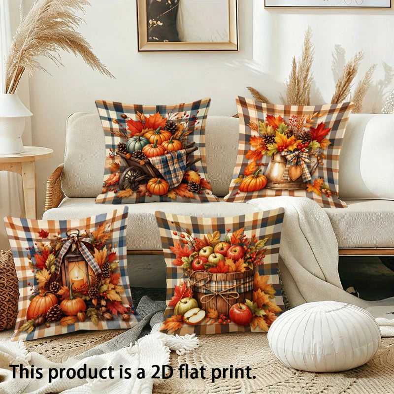 Four autumn-themed throw pillow covers displayed on a beige sofa in a styled living room. The pillows feature fall harvest prints with pumpkins, apples, pinecones, and plaid borders.