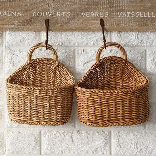 Two wicker baskets hanging on a textured white wall with French text above.