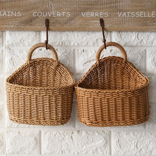 Two wicker baskets hanging on a textured white wall with French text above.