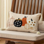 Decorative pillow with embroidered pumpkins on a wooden chair.