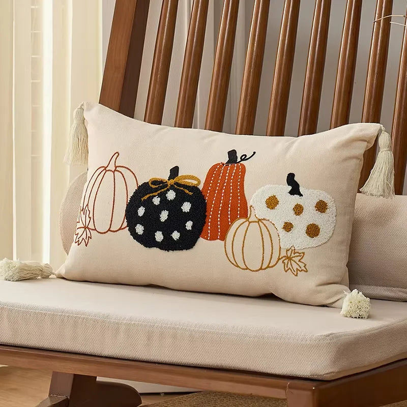 Decorative pillow with embroidered pumpkins on a wooden chair.