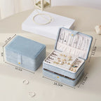 Blue jewelry box with jewelry inside, shown with dimensions on a light surface.