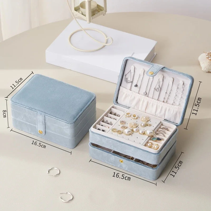 Blue jewelry box with jewelry inside, shown with dimensions on a light surface.