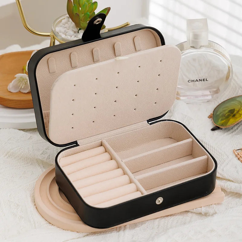 Open jewelry box with compartments on a white surface