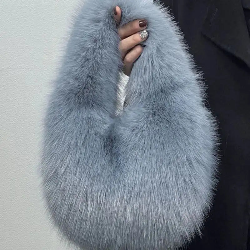 Blue faux fur scarf held by a person against a plain background