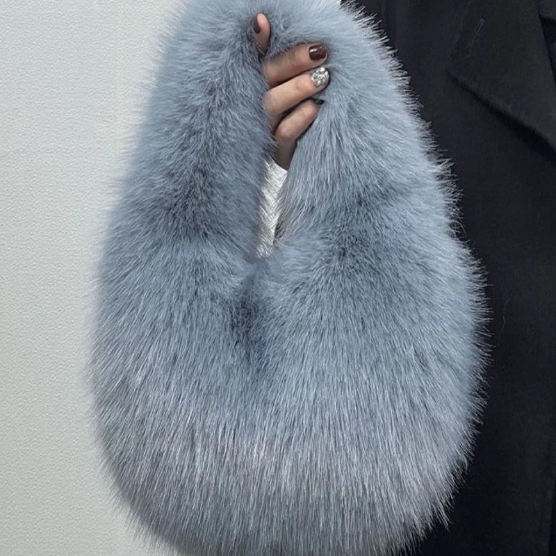Blue faux fur scarf held by a person against a plain background