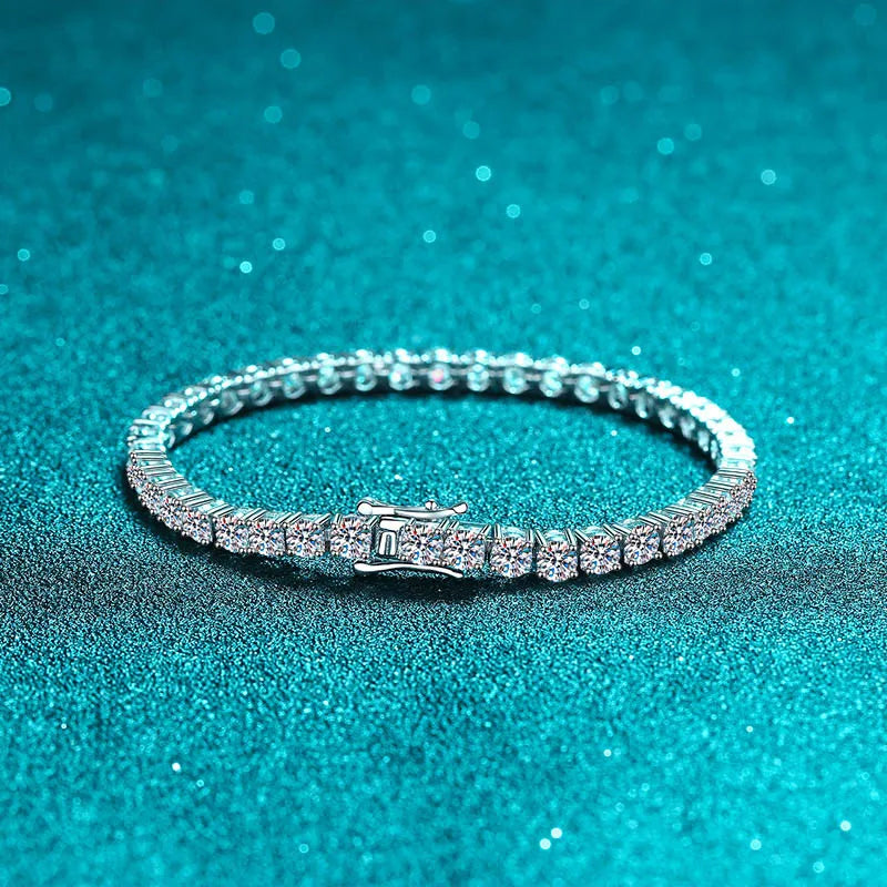 Silver bracelet with clear stones on a teal glittery background