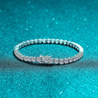 Silver bracelet with clear stones on a teal glittery background