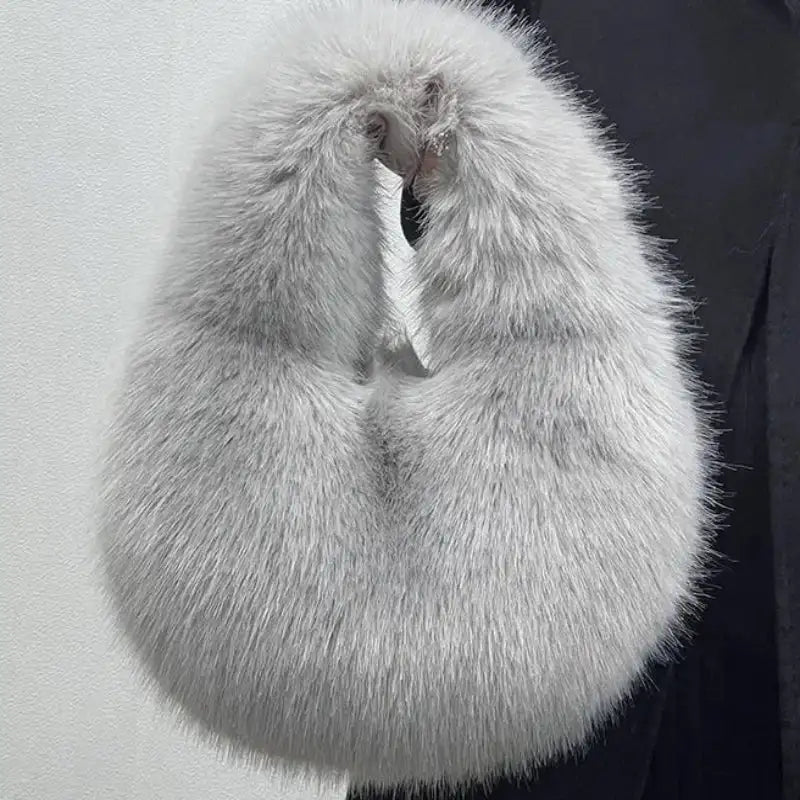 Gray fur stole held by a person against a light gray background