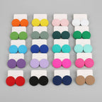 Colorful round earrings displayed in a grid on a gray tray.