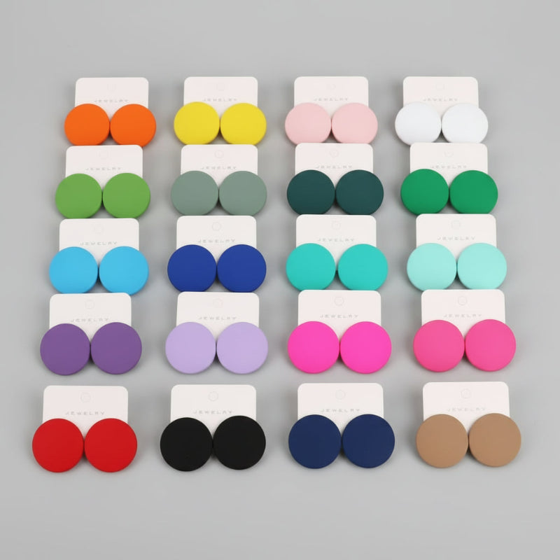 Colorful round earrings displayed in a grid on a gray tray.
