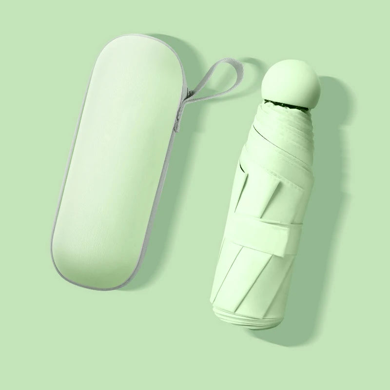 A light mint green compact umbrella and its matching zippered carrying case, shown on a solid pale green background with soft shadows.