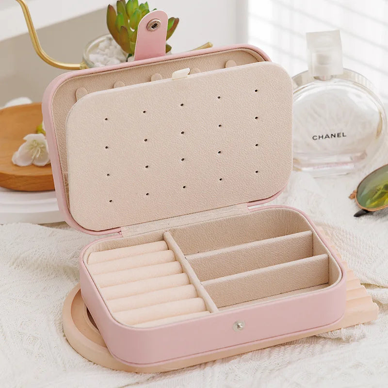 Pink jewelry box with compartments on a white surface
