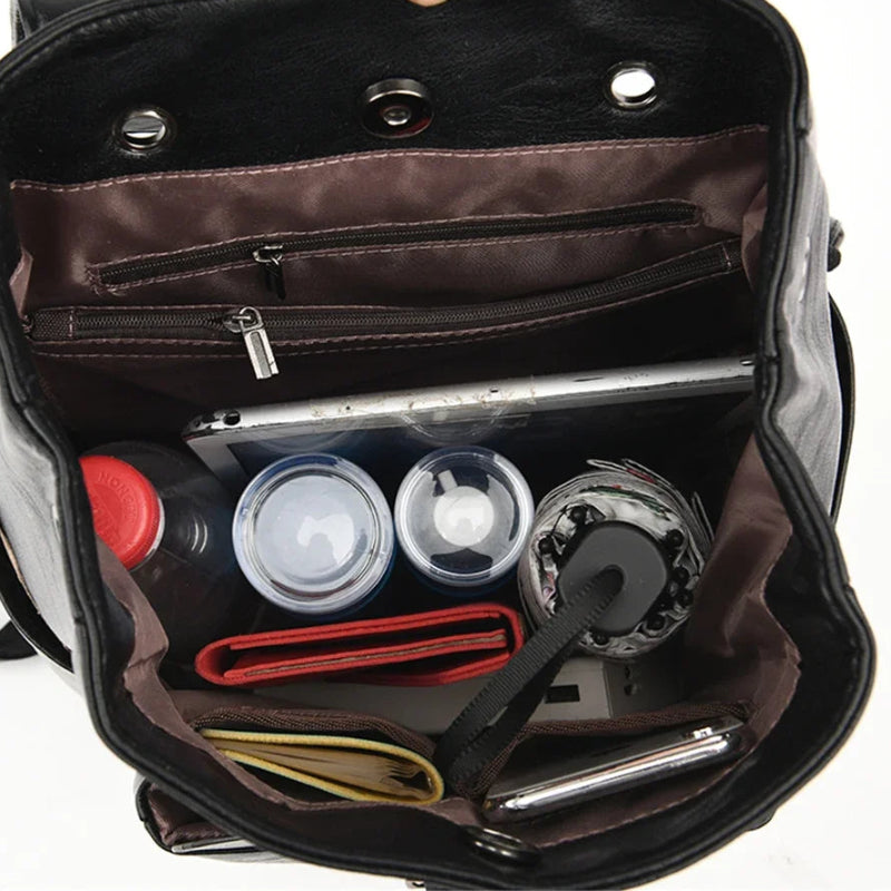 Open black backpack showing organized compartments with items inside