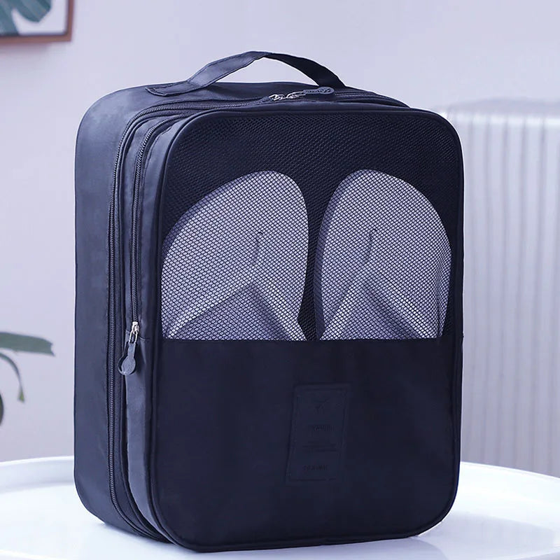 Black shoe bag with a compartment for shoes on a white surface.