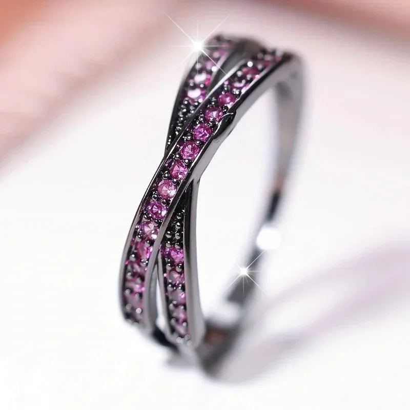 Silver ring with pink gemstones on a blurred background