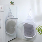 Mesh laundry bags hanging on a hook with clothes inside, next to a washing machine.