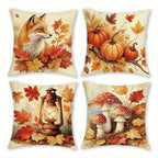Four square decorative throw pillows arranged in a 2x2 grid, each printed with a different autumn-themed illustration: a fox among leaves, pumpkins on a branch, a lantern surrounded by leaves, and red-and-white mushrooms with leaves. The pillows have a warm cream background and are shown on a plain white background.