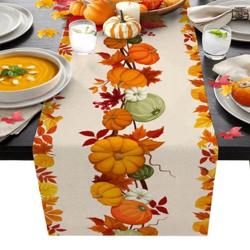Table setting with a decorative table runner featuring pumpkins and leaves on a gray table.