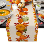 Table setting with a decorative table runner featuring pumpkins and leaves on a gray table.