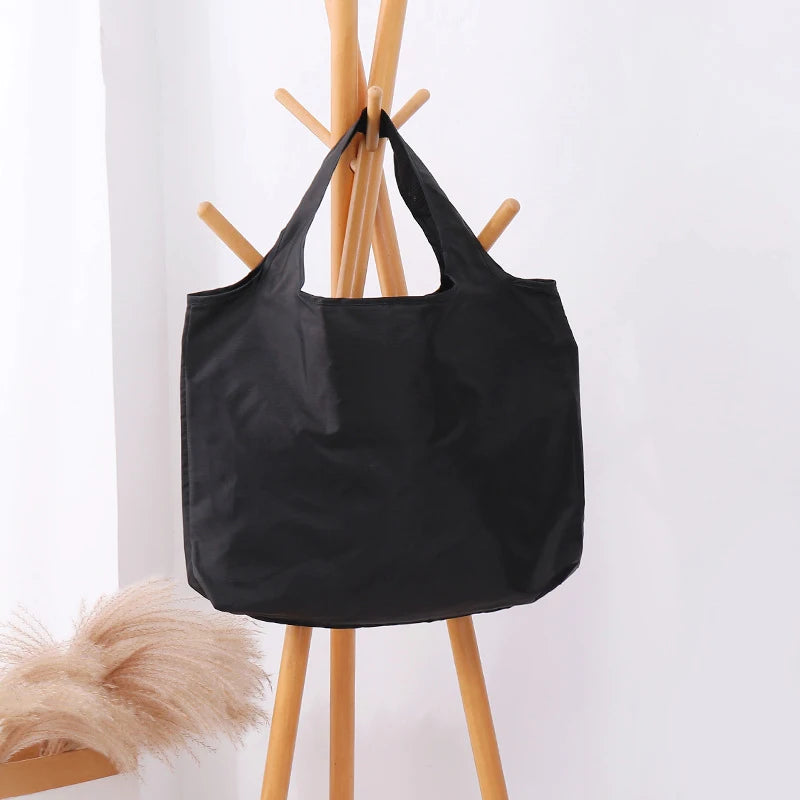 Black tote bag on a light gray background