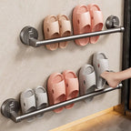 Shoe rack with pink and white slippers on a wall