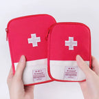 Two red first aid kits with white crosses held by hands against a light gray background