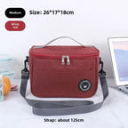 Red insulated lunch bag with gray strap on a white surface, with text indicating size and features.