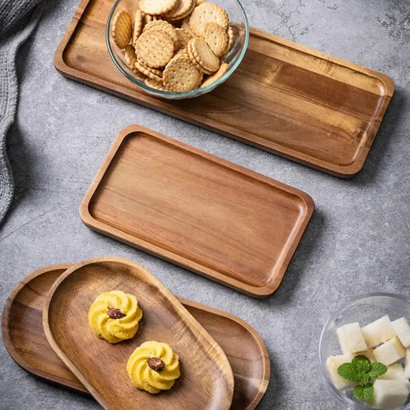Set of wooden trays with food items on a gray surface