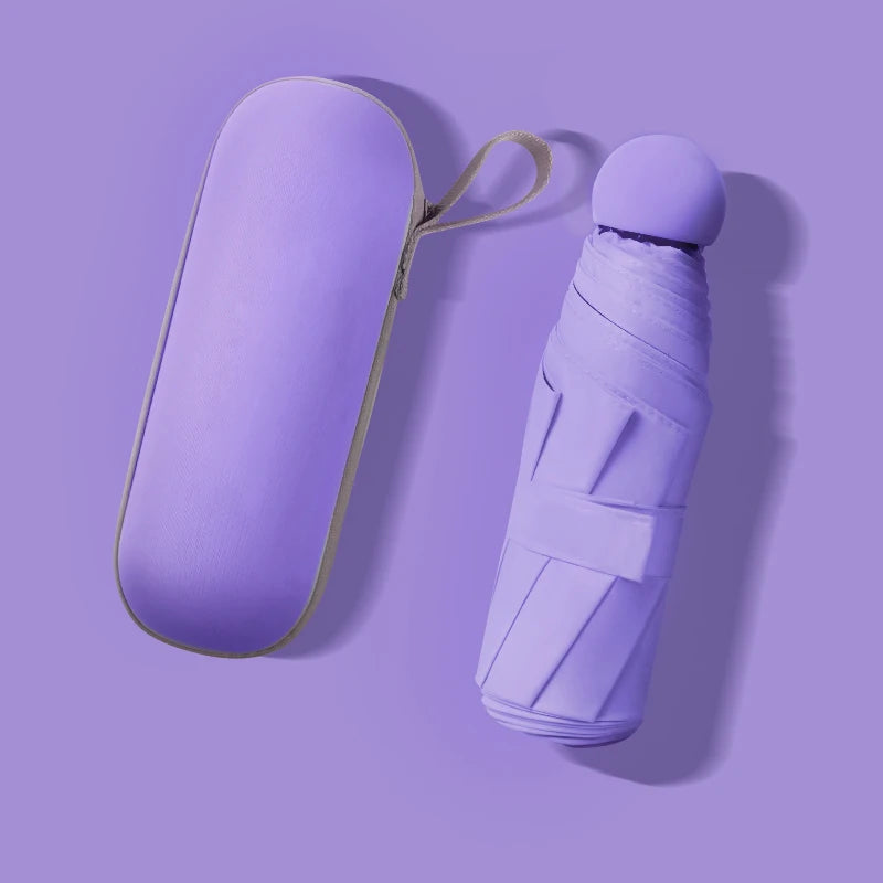 A compact purple folding umbrella and its matching hard-shell carrying case, shown on a solid lavender background.