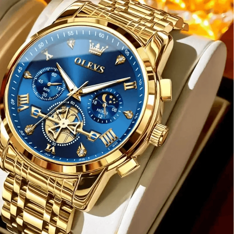 Gold watch with blue face on a white strap, branded OLEVS, on a dark background.