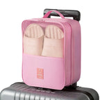Pink travel packing cube on a suitcase with a white background