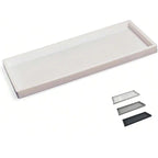 White rectangular tray with three black rectangular items on a white background