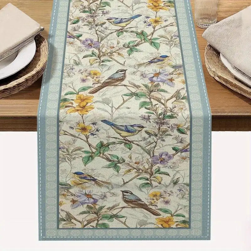 Decorative table runner with floral and bird pattern on a wooden table.