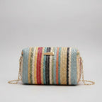 Multicolored striped handbag on a beige background with yellow tulips.